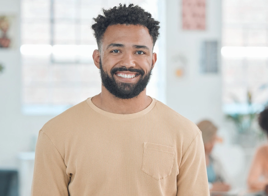 Smiling male patient in beige shirt at modern dental office setting