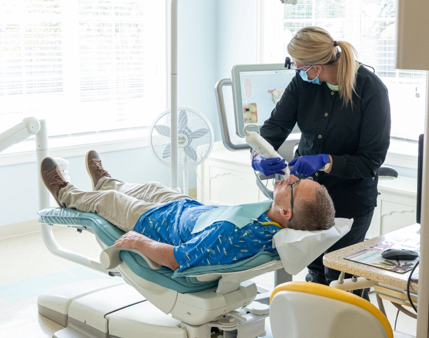 Dentist examining patient's teeth in modern dental clinic treatment room